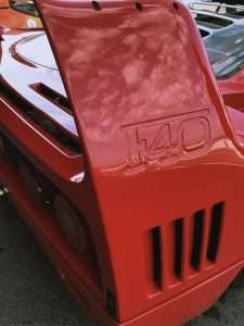 Detailed view of the iconic Ferrari F40's rear spoiler in vibrant red color.